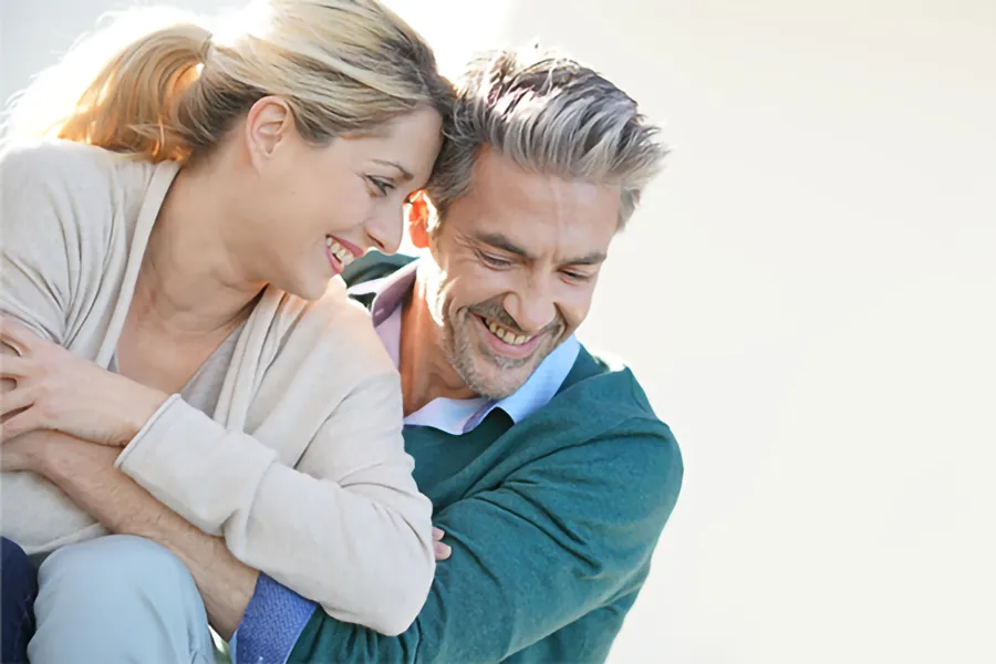 A happy middle-aged couple embracing in the sunlight. Get Hormone Replacement Therapy from ProCare Wellness Institute in Virginia Beach.