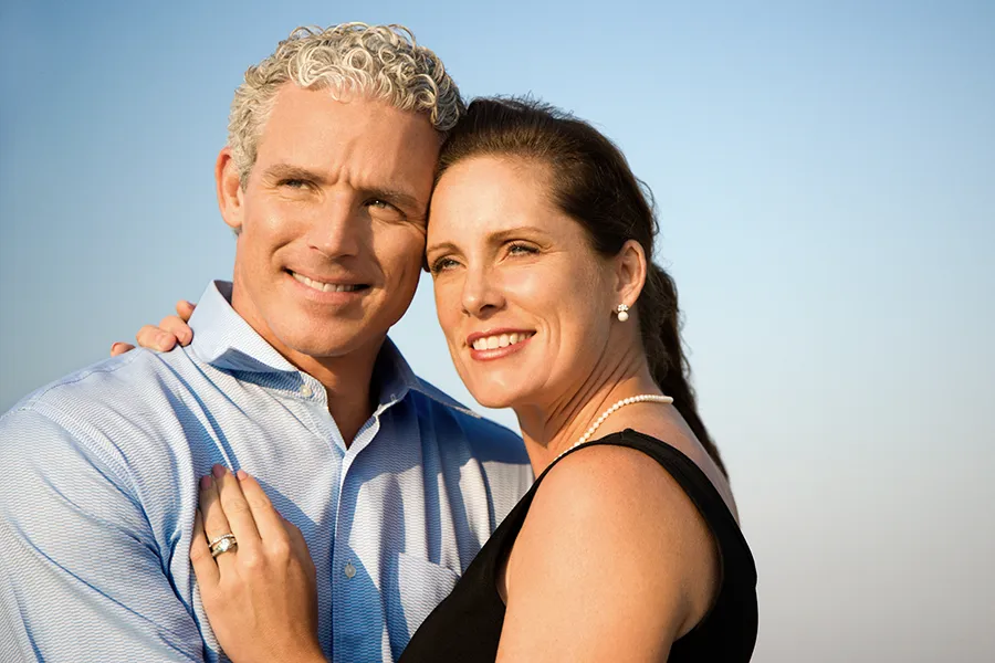 A middle-aged caucasian couple embraces in the sunshine, happy with the healthy aging peptide treatments from ProCare Wellness Institute in Virginia Beach