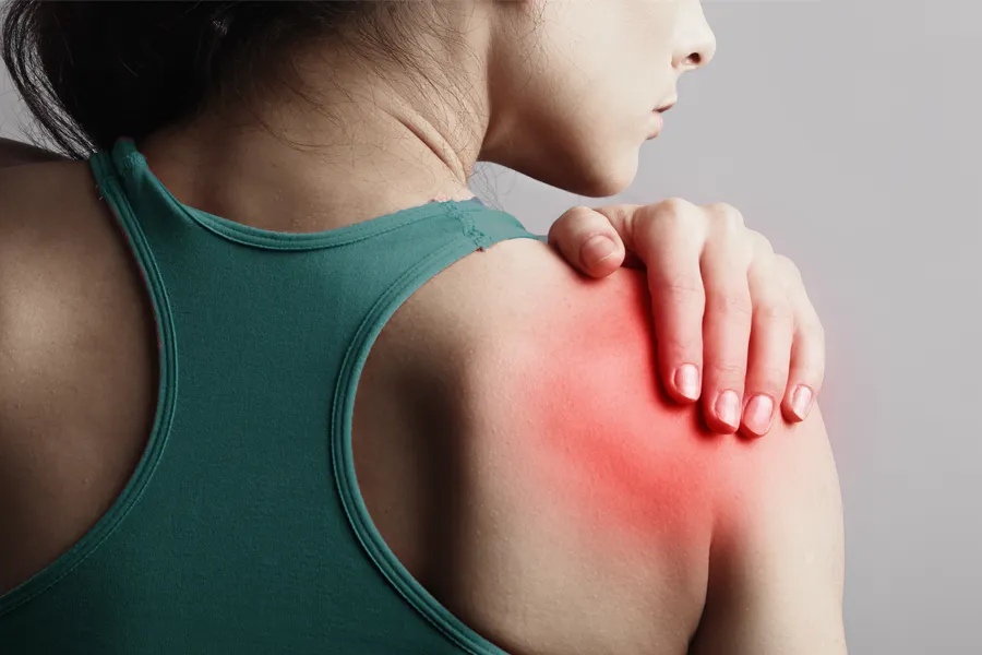 A woman holds her shoulder in pain. Schedule treatment for larum tears from ProCare Wellness Institute in Virginia Beach.