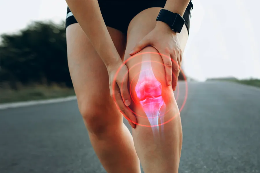 Close up of a female jogger holding her knee with an illustration of the knee joint with red radiating circles indicating pain, which can be relieved with PRP treatment for knee pain from ProCare Wellness Institute in Virginia Beach.