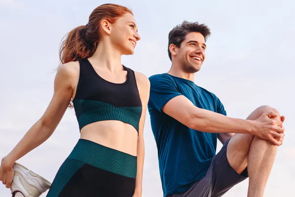 A couple in exercise clothes stretching and preparing for a run. Get Platelet Rich Plasma (PRP) treatment for sports and orthopedics from ProCare Wellness Institute in Virginia Beach.