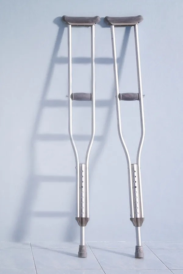 A pair of crutches rest against a gray wall, representing peptide therapy for healing and recovery from ProCare Wellness Institute in Virginia Beach.