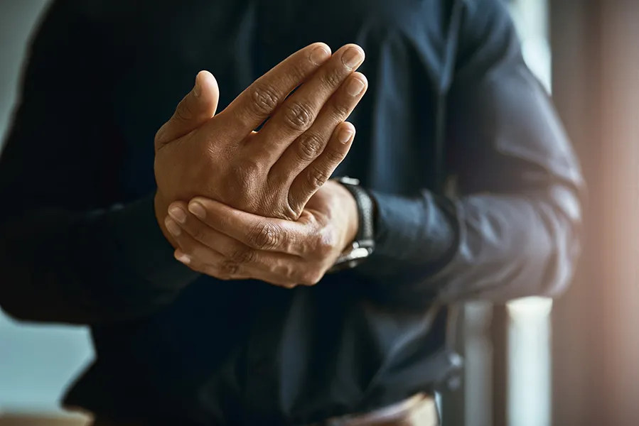 A man rubs his aching hand. Get treatment for Peripheral Neuropathy from ProCare Wellness Institute in Virginia Beach.