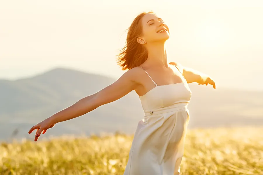 A woman with smooth, taut arms stretches them outside. Schedule Radiofrequency Microneedling for Arm skin from ProCare Wellness Institute in Virginia Beach.