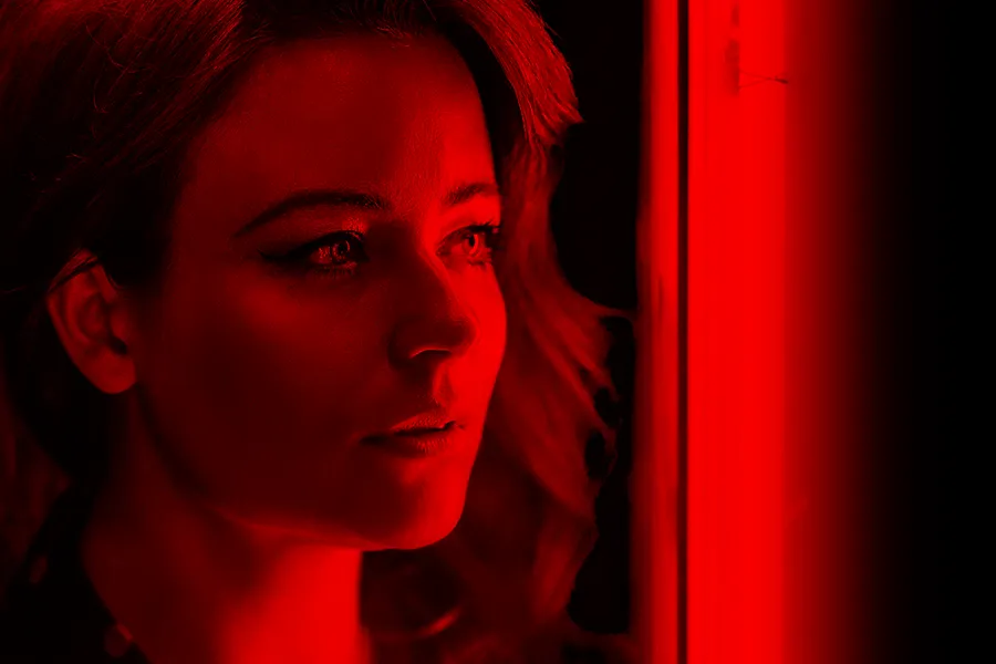 A woman in a red light. Get Red Light Therapy for Hair Restoration from ProCare Wellness Institute in Virginia Beach.