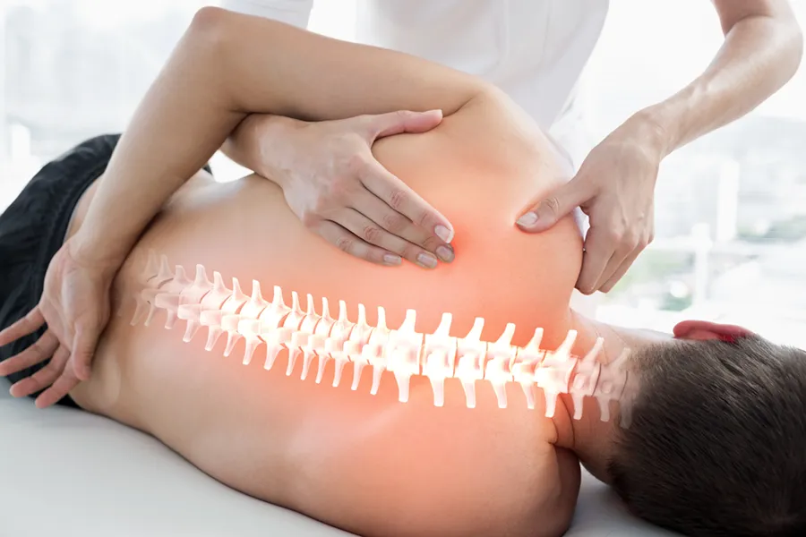 Spinal-Arthritis-and-Stenosis-Care-Clinic A clinician examines a man's spine. Schedule Spinal Arthritis and Stenosis Treatment from ProCare Wellness Institute in Virginia Beach.