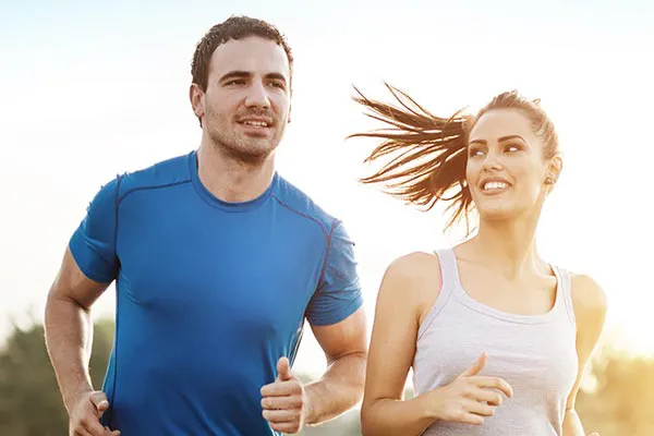 A couple happily jogging in the sunlight after receiving effective weight loss resistance care from ProCare Wellness Institute in Virginia Beach.