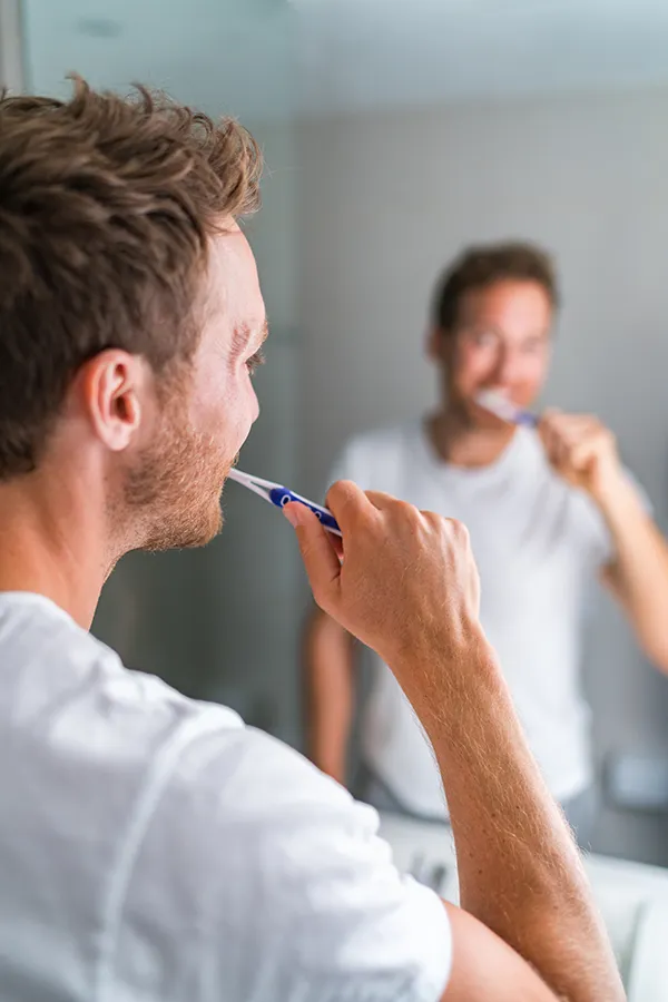 A man brushing his teeth. Get treatment for yellow teeth from ProCare Wellness Institute in Virginia Beach.